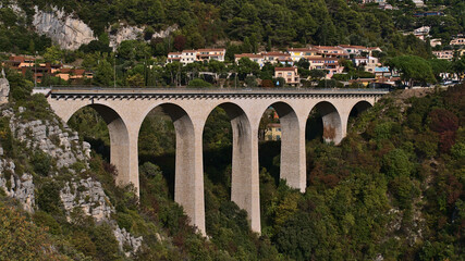 View of a beige colored road bridge with arches near small village Eze located on the hills above...