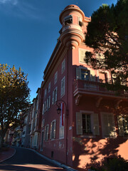 Cityscape of the historic center of Monaco (Monaco-Ville) with street Rue des Remparts, historic buildings and trees in the afternoon sun in autumn.