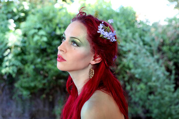 fantasy portrait of fairy girl with flowers in red hair and a pretty green dress,  posing in...