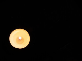 Burning candle on a dark background on the water