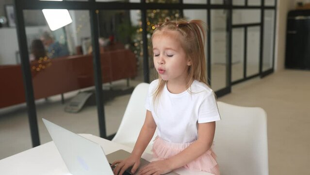 Little girl using tablet computer sitting at table