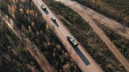 A military convoy is moving along the road. Aerial view.