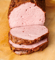 Frischer aufgebackener Leberkäse Fleischkäse in einer Semmel mit Ketchup Senf geschnitten zum mitnehmen