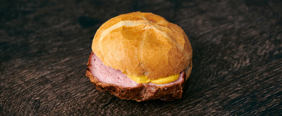 Frischer aufgebackener Leberkäse Fleischkäse in einer Semmel mit Ketchup Senf geschnitten zum...