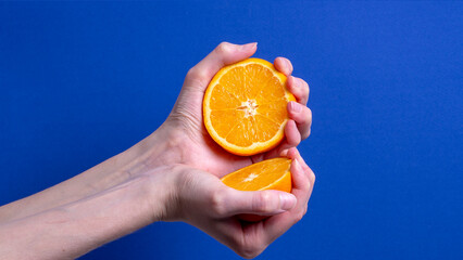 woman's hand holding a cut ripe orange