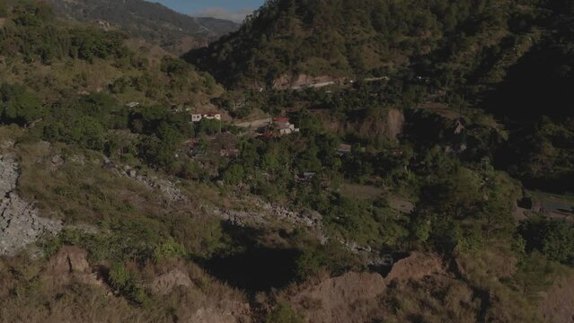 remote village town in mountainous tropical region Kabayan Benguet Philippines aerial fast reversing wide angle revealing valley rockslide