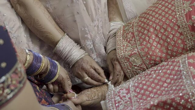 Dehradun, Uttarakhand India February 21, 2022. Indian Bride getting ready for her traditional Indian Wedding, helping bridesmaid.wearing jewelry, Lehnga. High quality FullHD footage