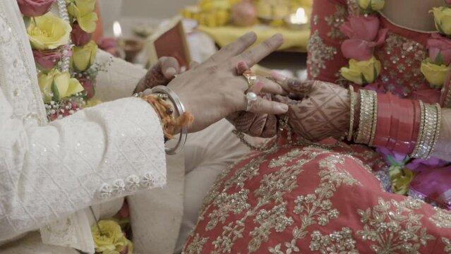 Ring ceremony in Traditional way at an Indian Wedding ceremony. Bride and groom sitting, holding rings in their hand. High quality FullHD footage