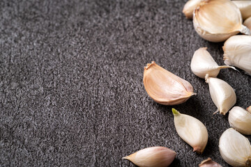 Fresh garlic cloves on black table background.
