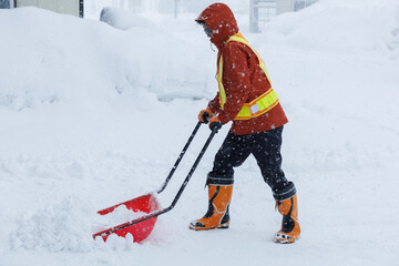冬に雪寄せ作業をしている男性　スノーダンプ