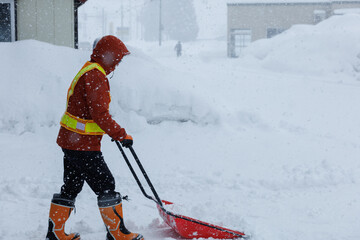 冬に雪寄せ作業をしている男性　スノーダンプ
