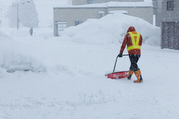 冬に雪寄せ作業をしている男性　スノーダンプ