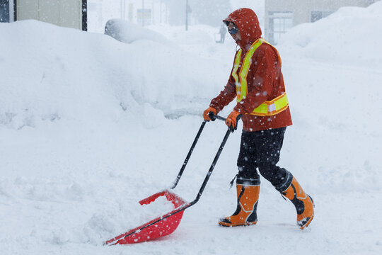 冬に雪寄せ作業をしている男性　スノーダンプ
