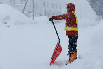 冬に雪寄せ作業をしている男性　スノーダンプ
