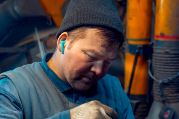 Portrait of a welder with a microphone in his ear at the workplace
