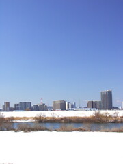 Fototapeta premium 土手から見る早春の雪の残る江戸川河川敷風景
