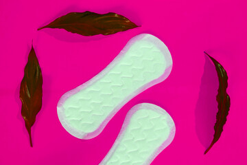 women's pads with leaves on a pink background 