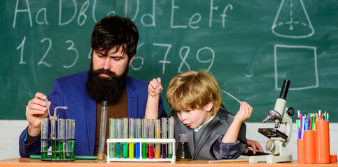 Innovation. Laboratory test tubes and flasks with colored liquids laboratory research and development. bearded man teacher with little boy. father and son child at school. Chemistry beaker experiment