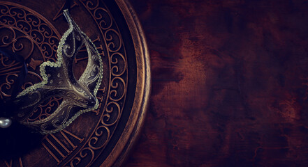 Photo of black with gold elegant Venetian mask over grunge background