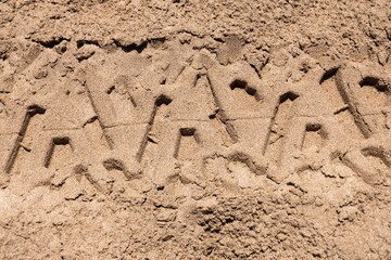 Top view of sand with tire marks.