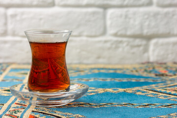 Black tea in armudu glass on wooden background