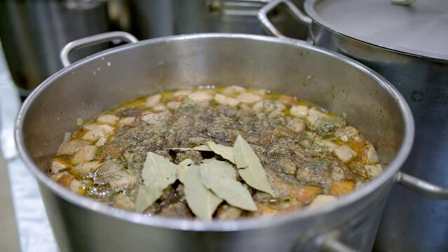 zupy, wsypywanie majeranku do zupy, wrzucanie liści laurowych do zupy / pouring herbs into boiling soup, cooking soup, pouring marjoram into soup 