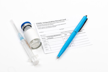 Covid-19 vaccine vial, vaccination record card, syringe, a pen  Coronavirus vaccination concept. - Image