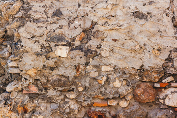 Texture of old wall from stones stained with mortar. Horizontal photo.