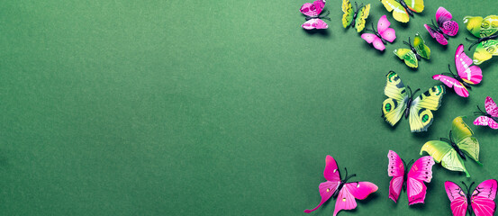 Abstract green background with artificial green and purple butterflies. Long banner with copy space