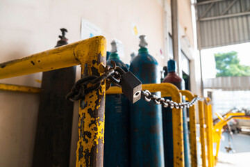 The padlock is hanging on the chain. argon tank storage. Oxygen tank set hurts well. Oxygen tank tank in the factory. Old argon tank storage in factory.