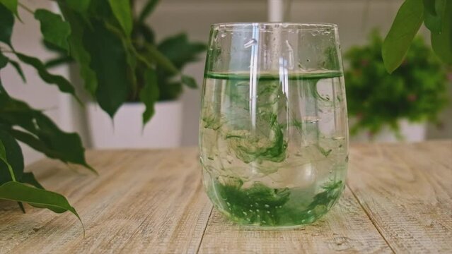 Liquid chlorophyll in a glass of water. Selective focus.