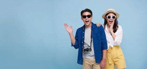 Excited Asian couple tourist dressed in summer clothes to travel on holidays isolated on blue copy...