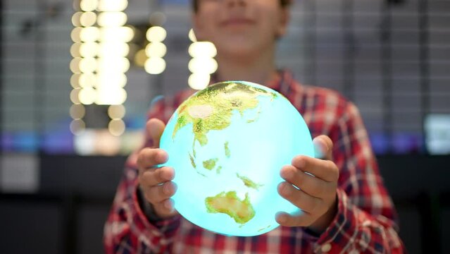 Boy child holding planet Earth globe in hands looking at camera, Save Planet, Help No Plastic, Recycling, Concept save our green planet and climate change due global warming - future ecology nature