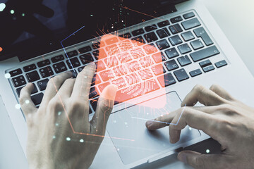 Multi exposure of abstract fingerprint scan interface with hands typing on computer keyboard on background, digital access concept