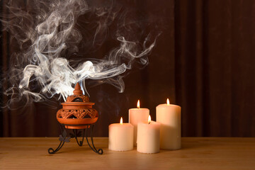incense burning in an incense burner with candles on the table for praying Buddha or Hindu gods to...