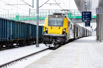 Pociąg transportowy przejeżdżający na stacji kolejowej zimą