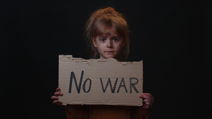 Upset poor toddler girl kid homeless with dirty face protesting war conflict raises banner with...