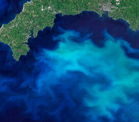 Blooms of phytoplankton in the sea around England, aerial top view photo of blue sea from clear sky, turquoise ocean image background. Elements of this image furnished by NASA.