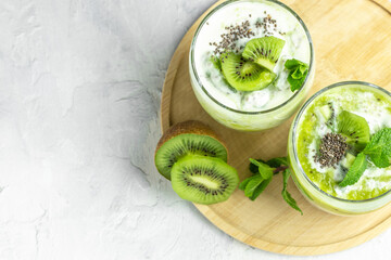 Naklejka na ściany i meble Chia pudding in a glass. Healthy breakfast. chia pudding with kiwi on light background. Long banner format. top view