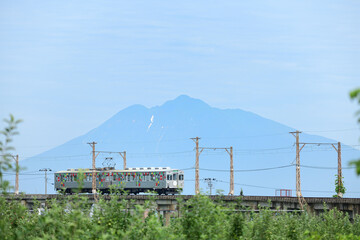 岩木山を背景に走る弘南鉄道のローカル電車