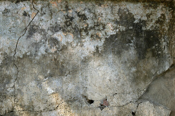 Old cement wall with cracks and stains.