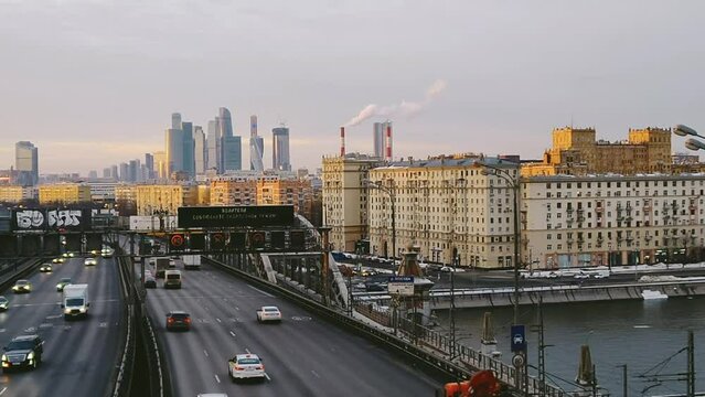 Heavy traffic of cars and trucks on the Andreevsky bridge over the Moscow river. An urban landscape with office skyscrapers in the background. Cars on the city highway. Moscow, Russia.
