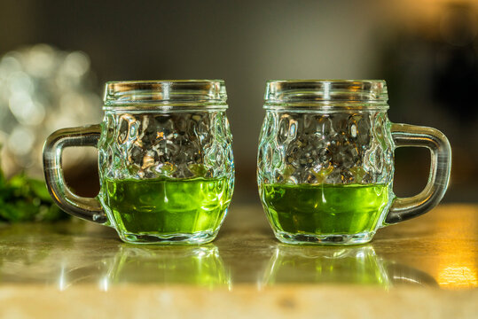 Green absinthe in glasses with handles