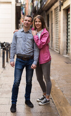 Naklejka premium young couple guy and girl hugging walking along streets of european city