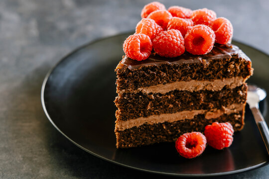 Chocolate layer cake slice with dulce de leche butter cream, ganache and raspberry