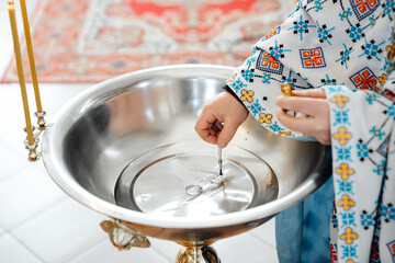 The sacrament of the baptism of a child in an Orthodox church, the priest anoints the baby's feet...