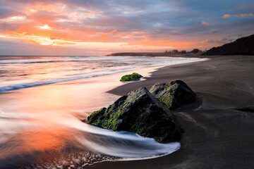 Magnifique coucher de soleil sur la plage avec des rochers