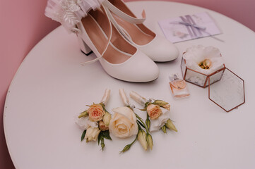 Bride's accessories. Gold wedding rings, boutonniere of the groom, for the bride, wedding invitation