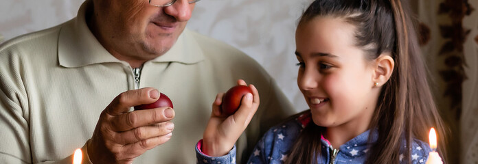 happy grandfather and granddaughter hold easter eggs in hand, folk game beats easter egg