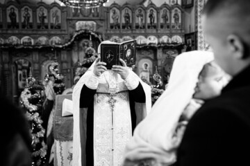 The sacrament of the baptism of a child in an Orthodox church, the priest anoints the baby's feet...